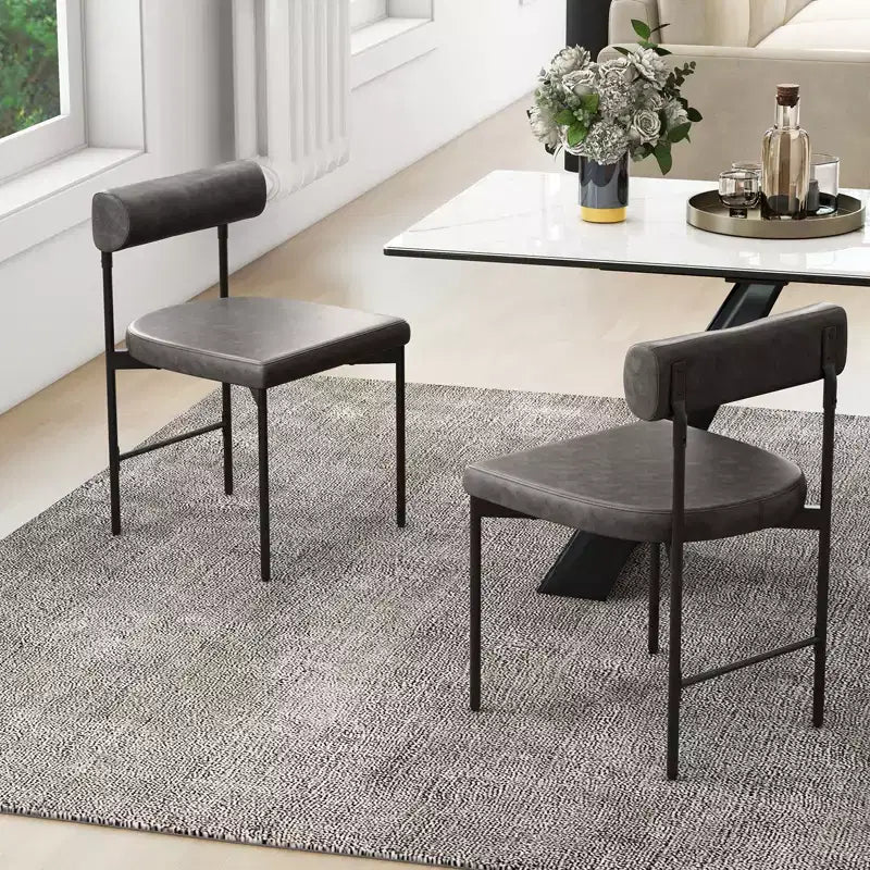 Chaise de salle à manger en similicuir avec dossier incurvé.